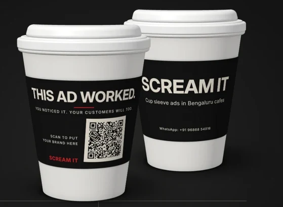 Two Scream It coffee cups with black advertising sleeves
